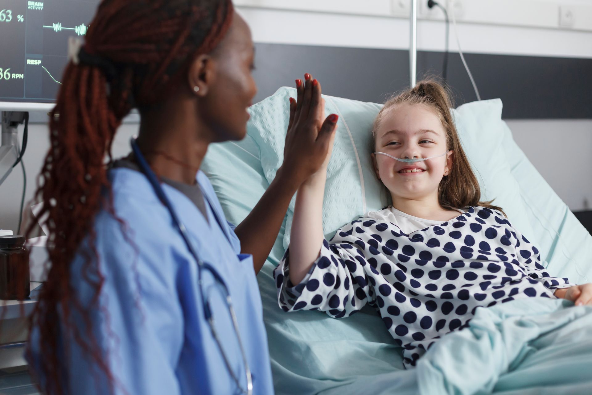 Une infirmière et une enfant se tapent dans la main