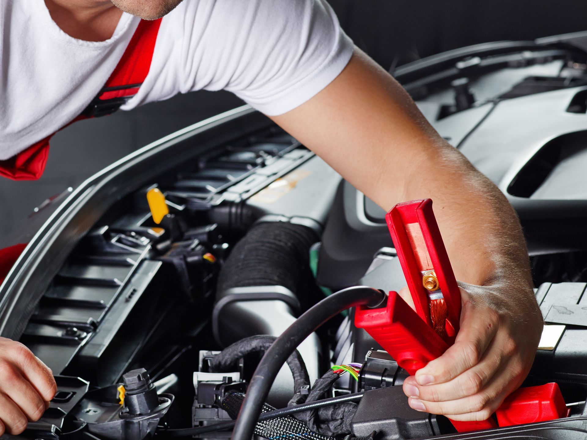 Un mécano installe un câble sur la batterie d'une voiture.