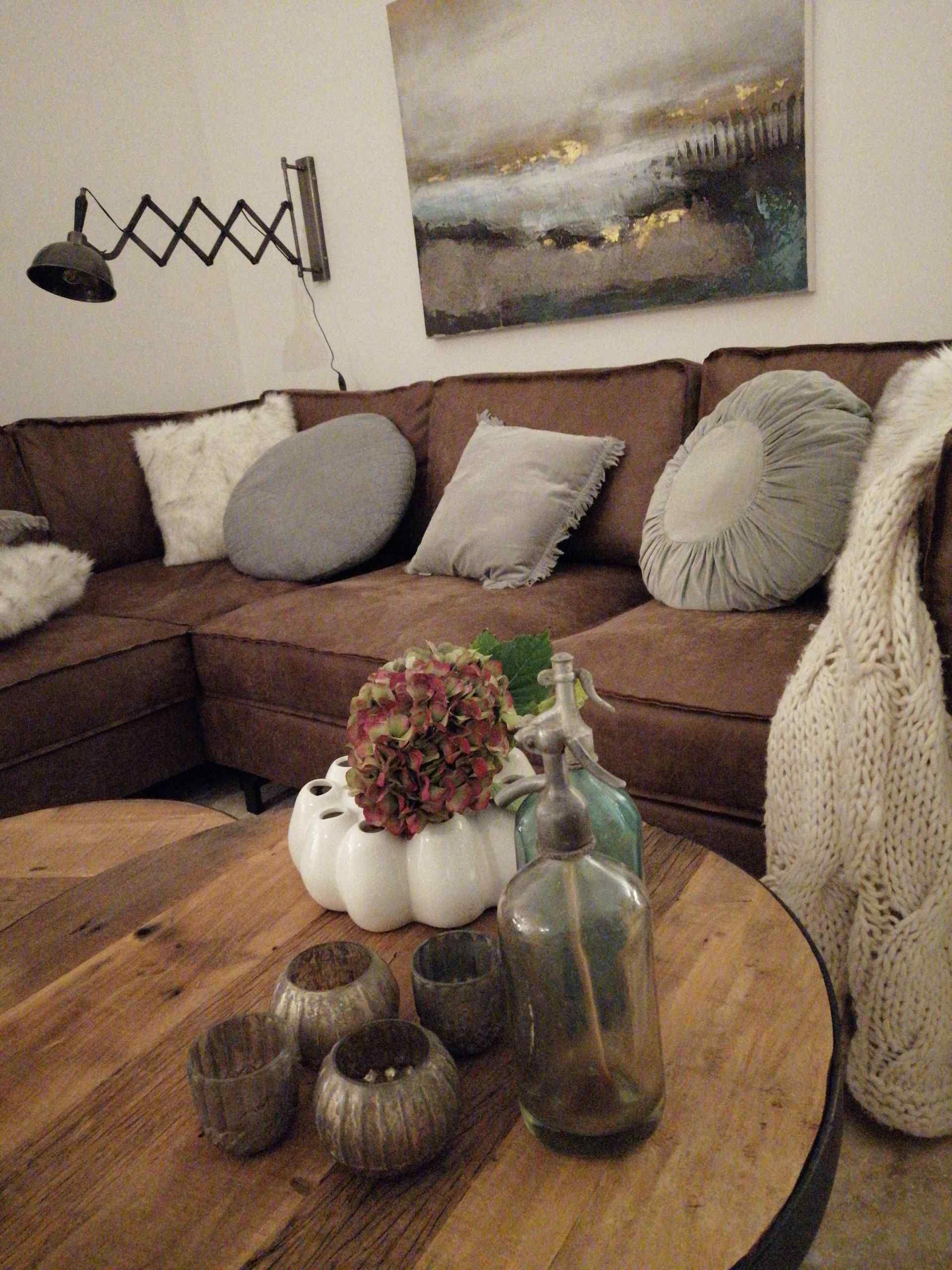 Braune Rauledersofabank mit einem Holztisch