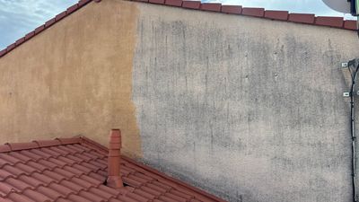 Façade d'un bâtiment partiellement nettoyée, montrant le contraste entre les couleurs de l'enduit jaune d'origine délavé et du nouvel enduit jaune.