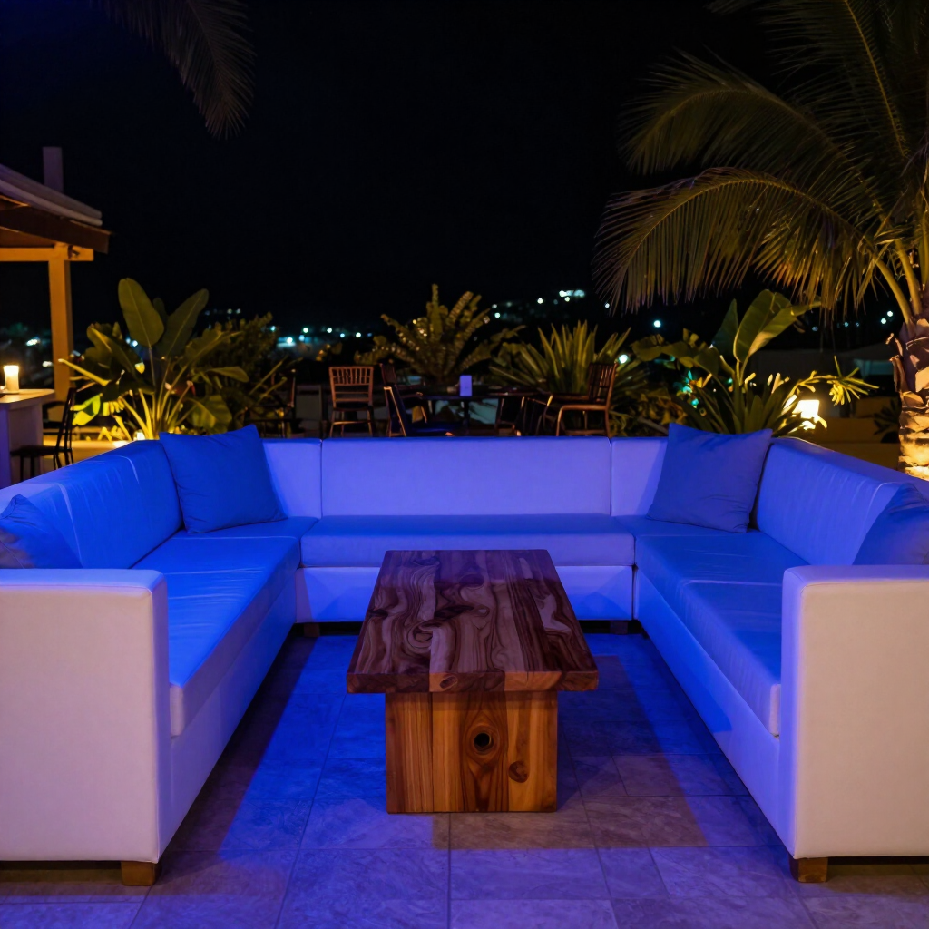 Canapé d'angle bleu d'extérieur avec table basse en bois sur une terrasse éclairée la nuit