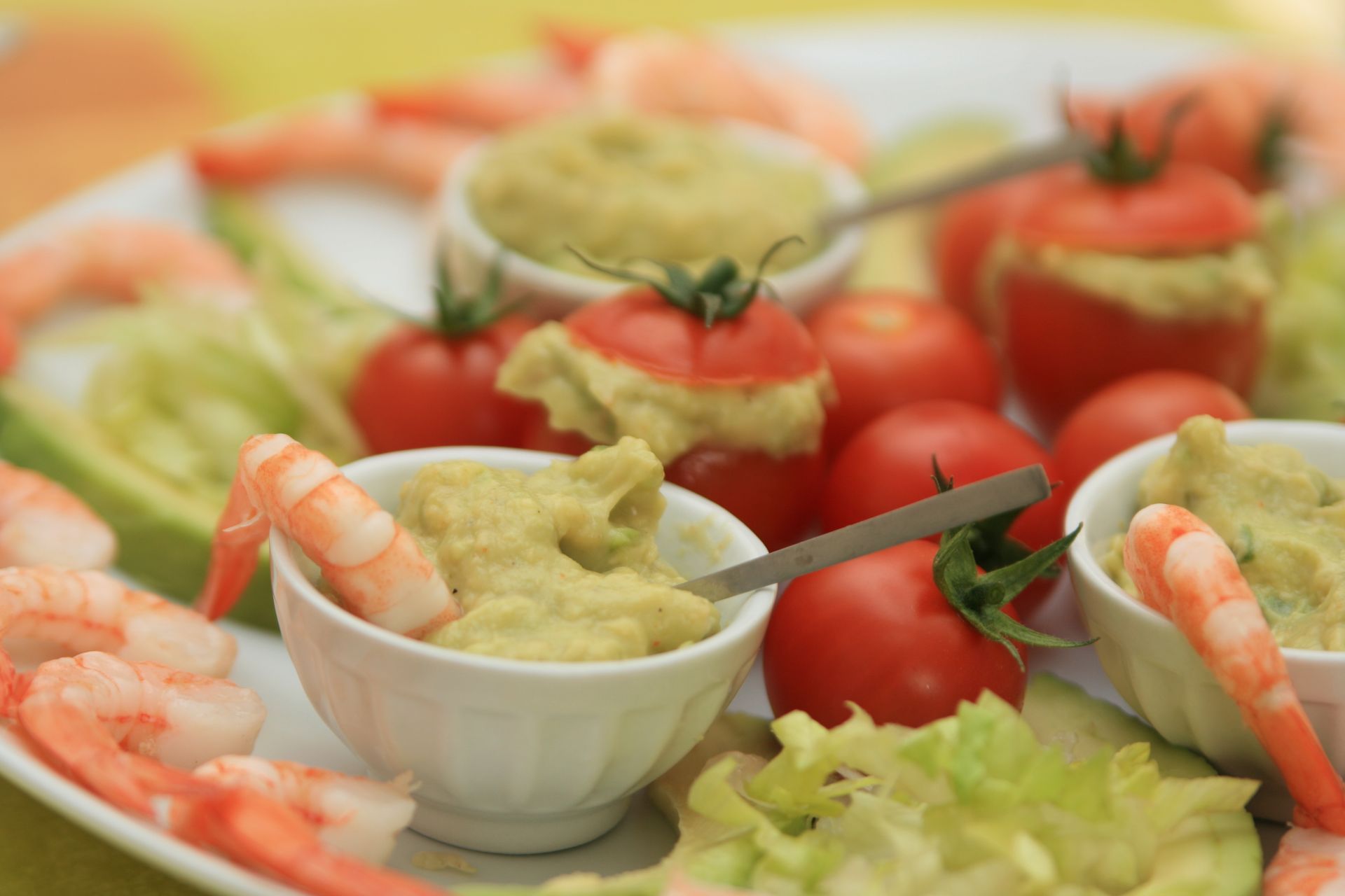 Cocktail de crevettes et guacamole en apéritif, servis sur un plateau avec garniture de tomates et de laitue.