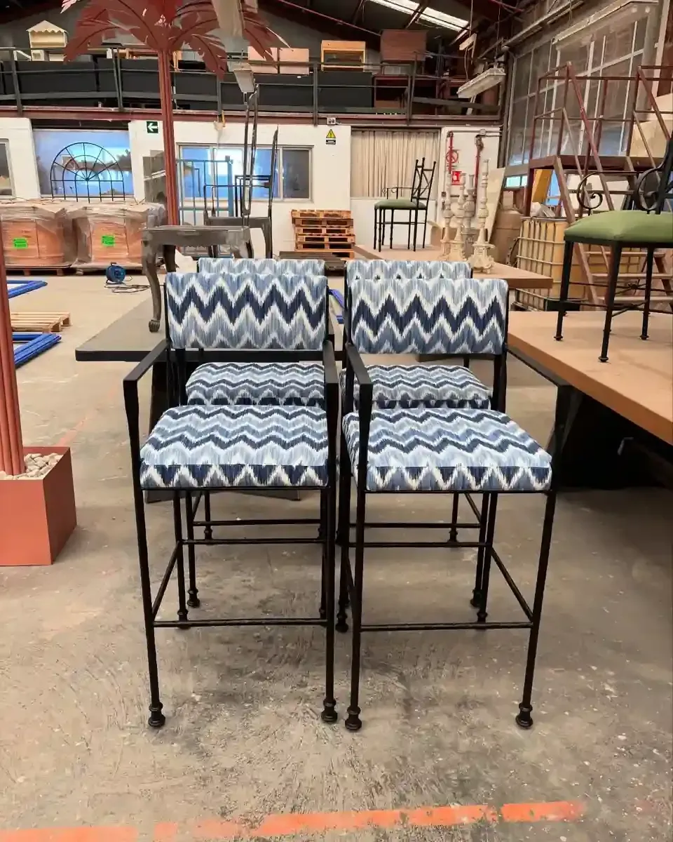 Edificio blanco siendo pintado por un trabajador en un ascensor, día soleado.