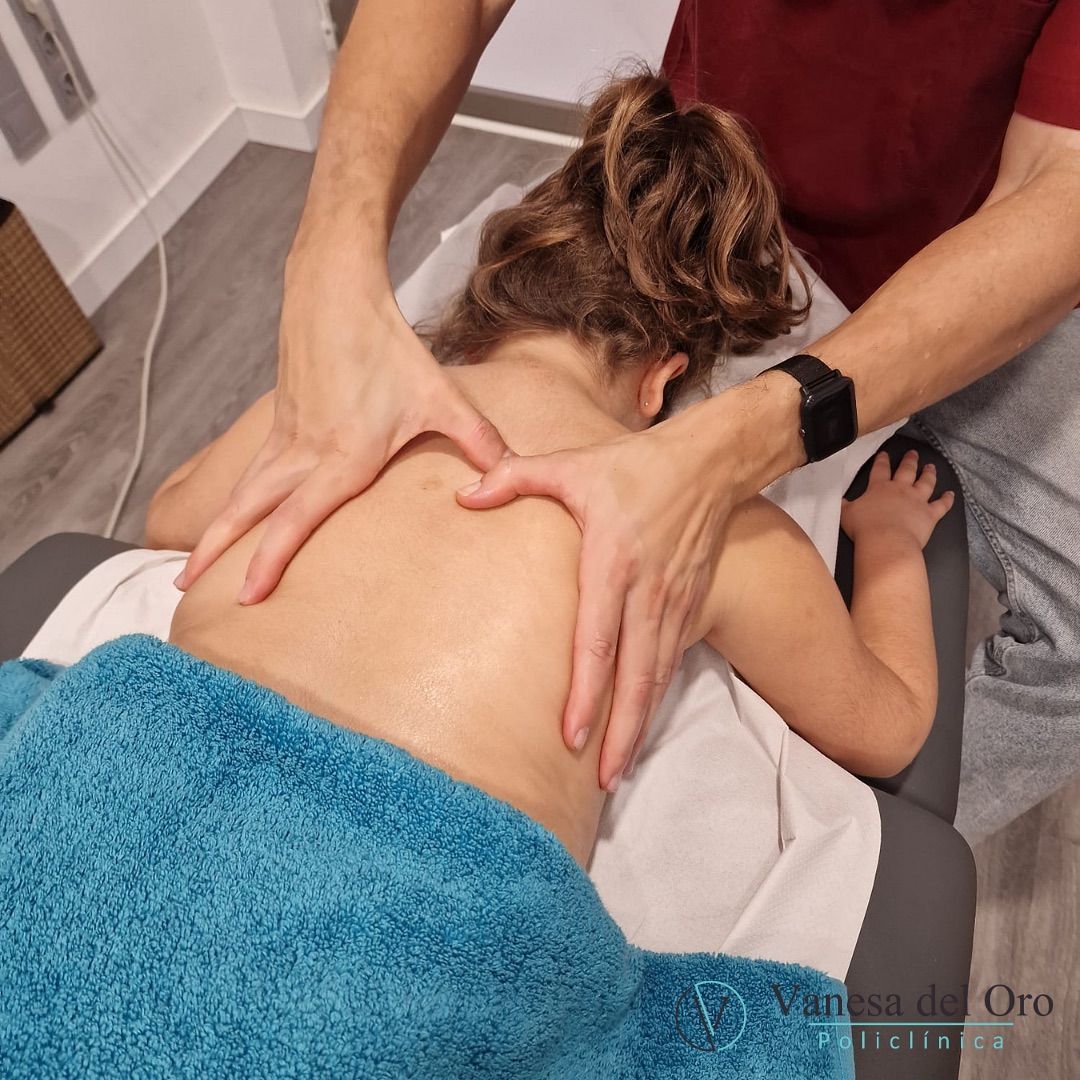 Una mujer está acostada en una mesa recibiendo un masaje de un hombre que lleva un reloj.