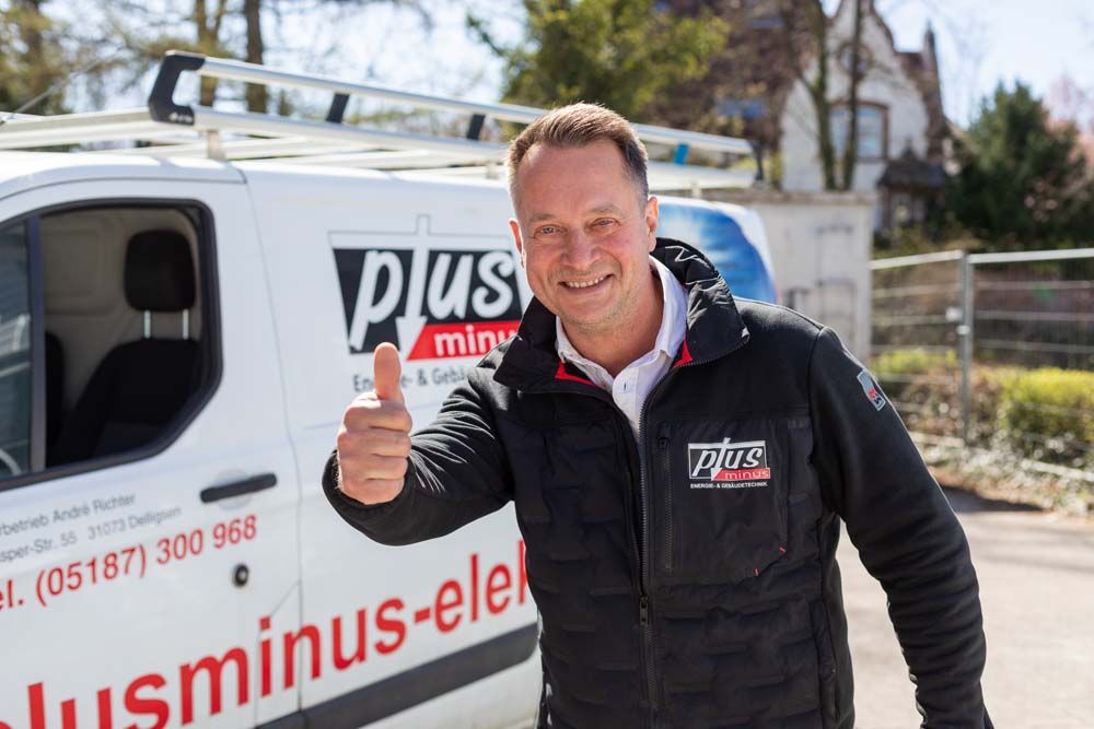 Mann mit erhobenem Daumen vor Lieferwagen; Lieferwagen mit Firmenlogo, Außenansicht.