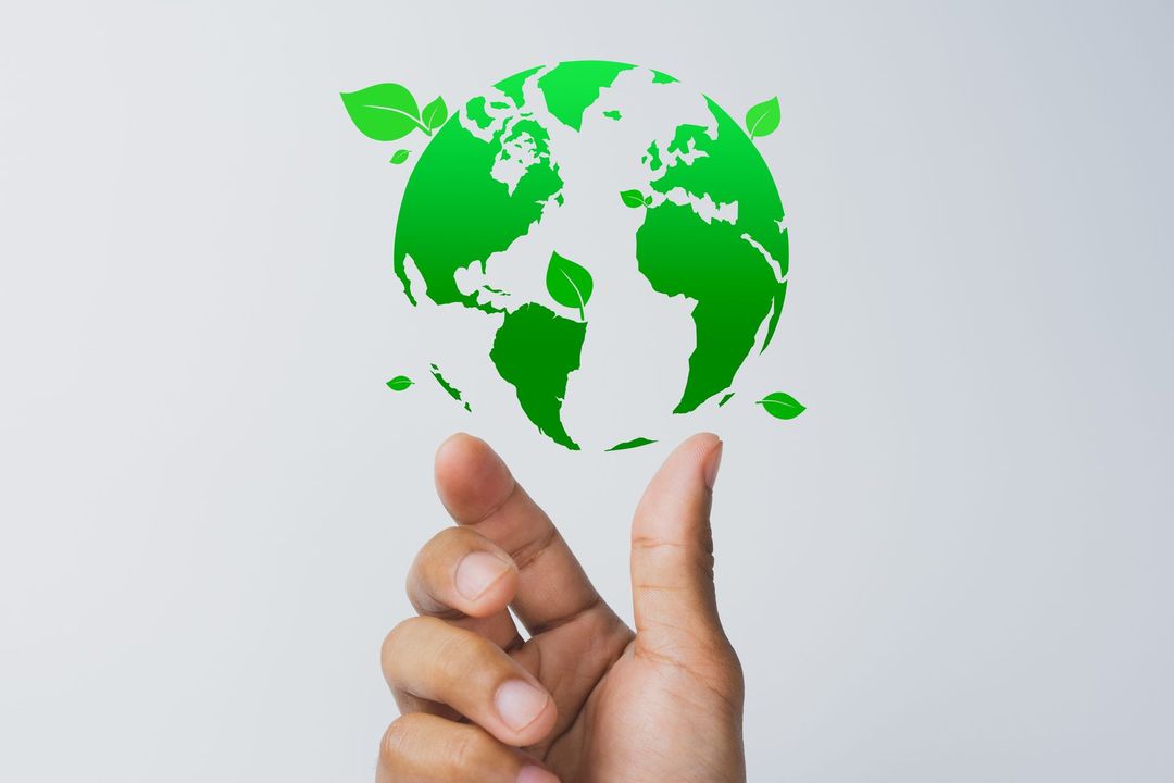 Une main tenant en équilibre une Terre verte avec des feuilles, symbolisant la protection de l'environnement.