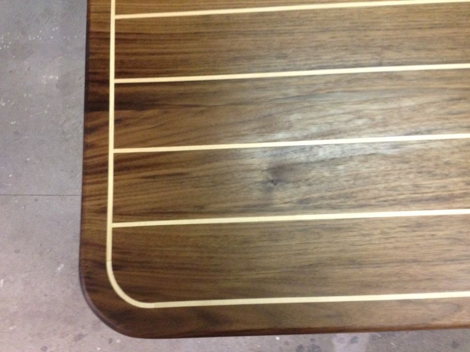 Detailaufnahme einer Tischplatte aus dunklem Holz mit Maserung