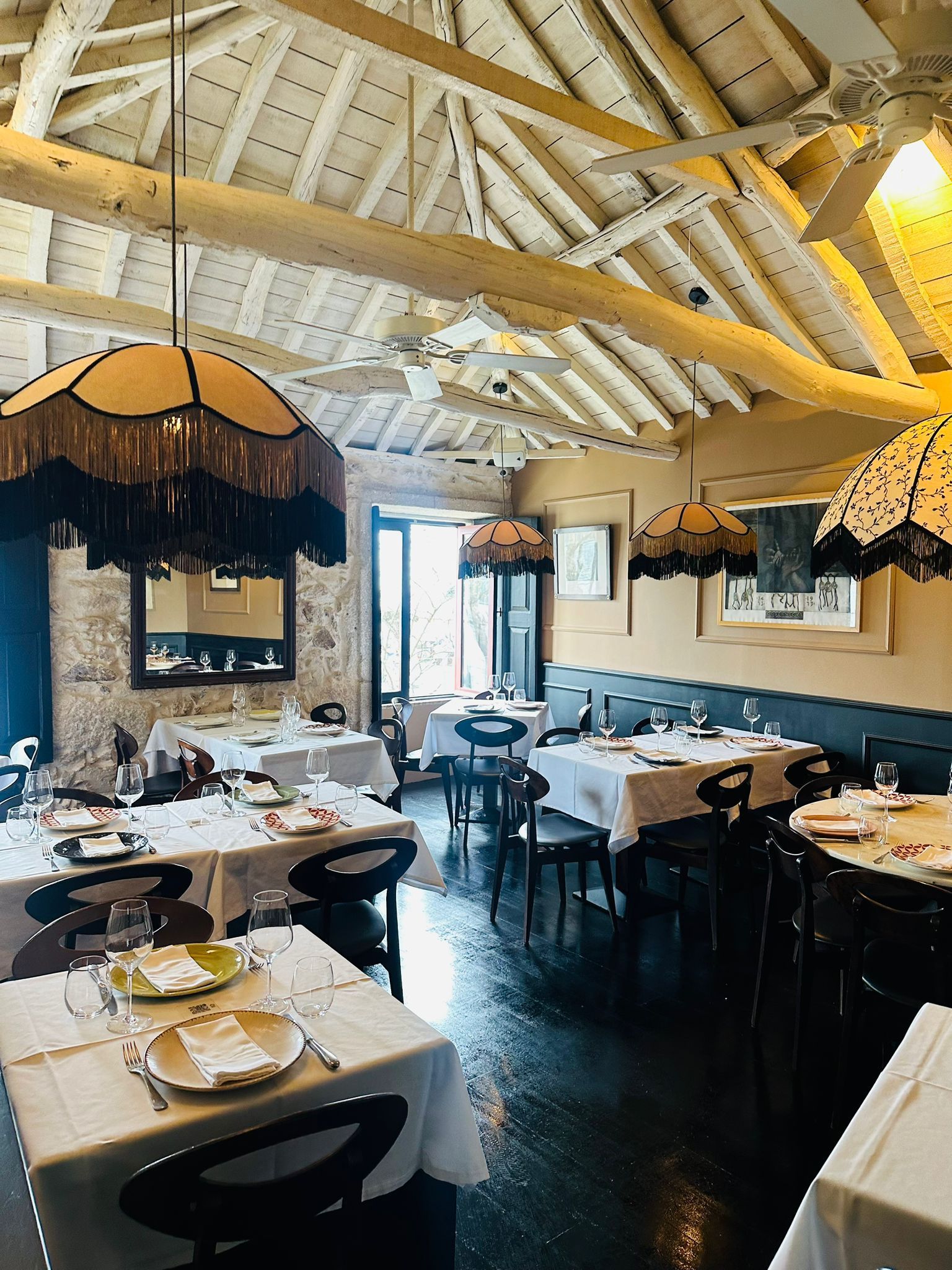 Um restaurante cheio de mesas e cadeiras com pratos e copos sobre elas