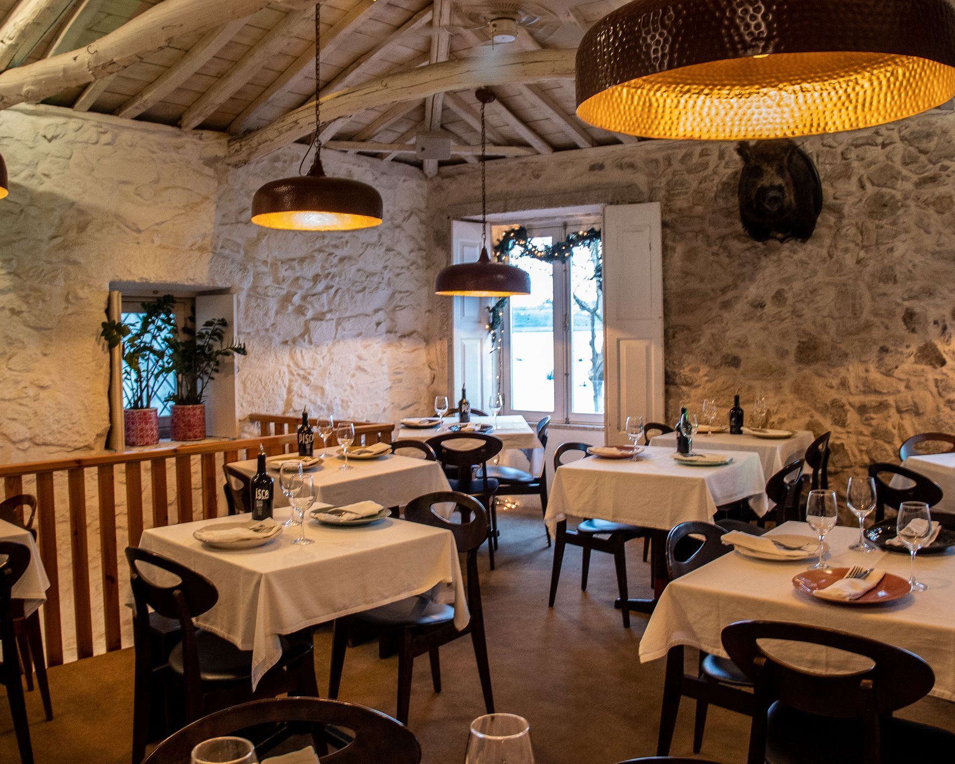 Um restaurante cheio de mesas e cadeiras com pratos e copos sobre elas