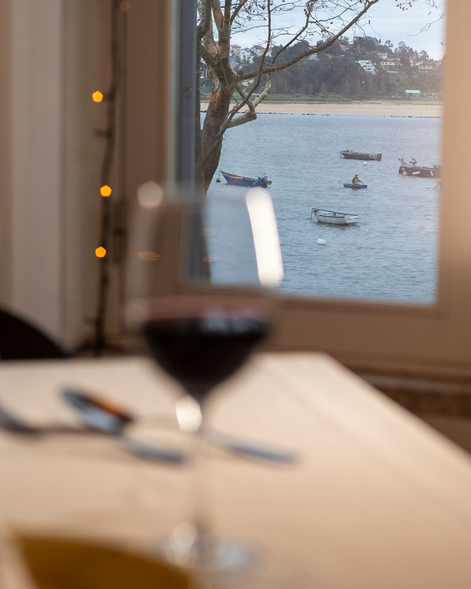 Uma taça de vinho está sobre uma mesa com vista para o oceano.