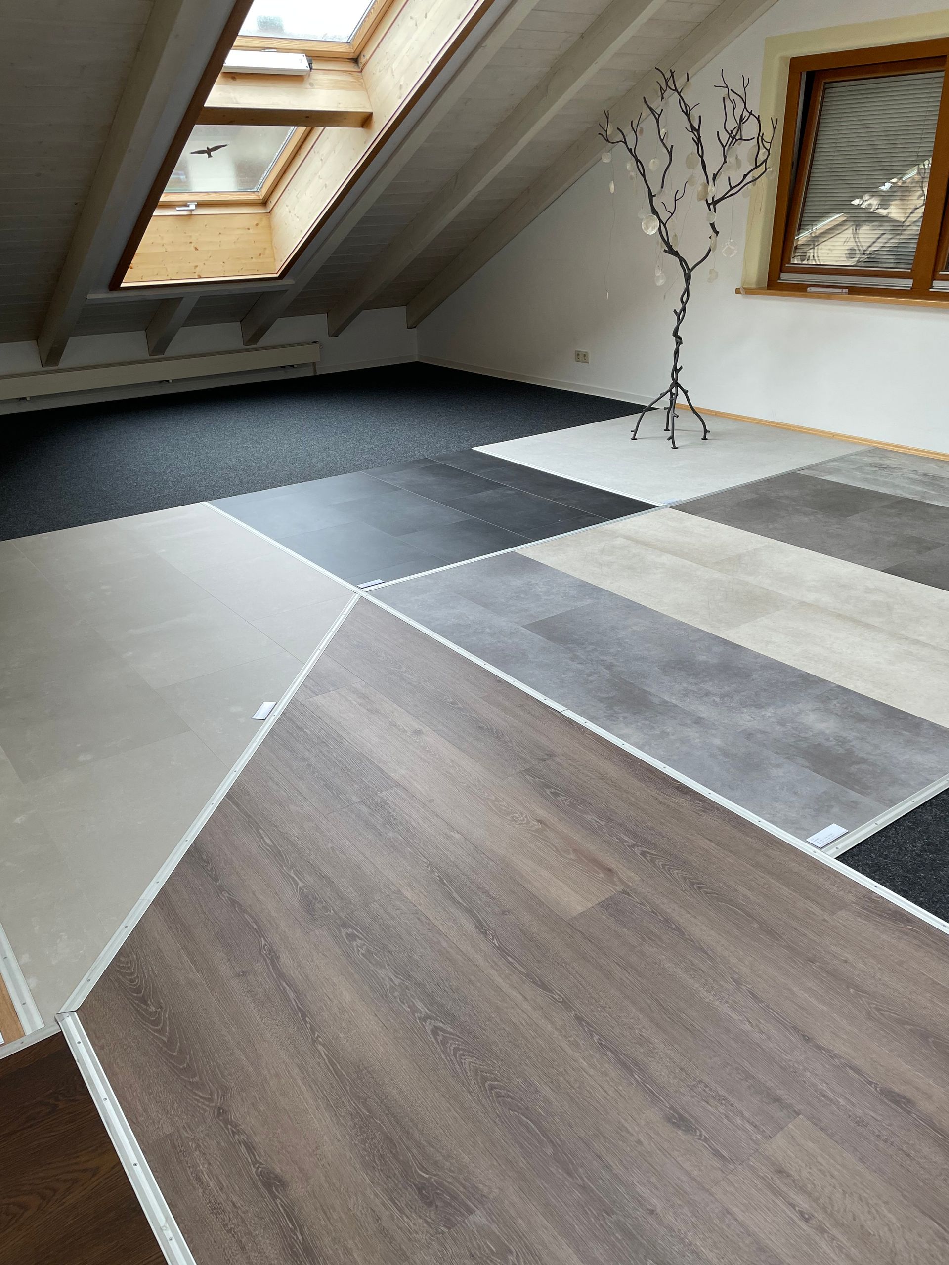 Moderne Küche mit goldenen und schwarzen Schränken, Kochinsel, Holzböden und Blick auf eine Terrasse.