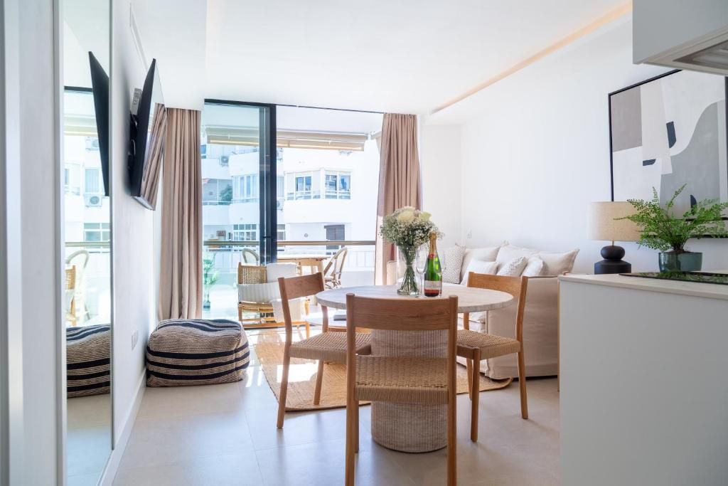 Piscina con agua cristalina, palmeras y edificios blancos al fondo.