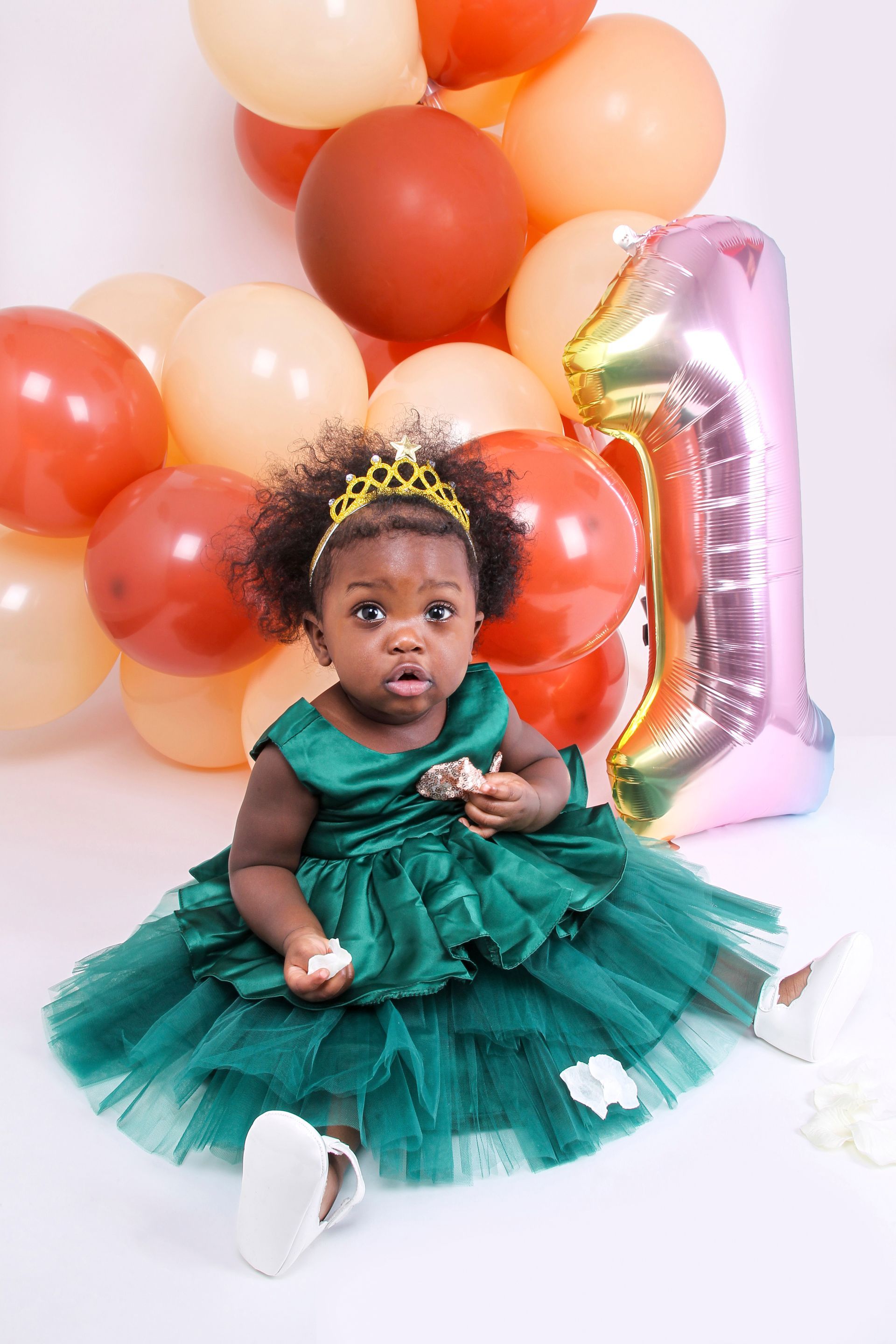 Photo d'une petite fille vêtue d'une robe de princesse et entourée de ballons