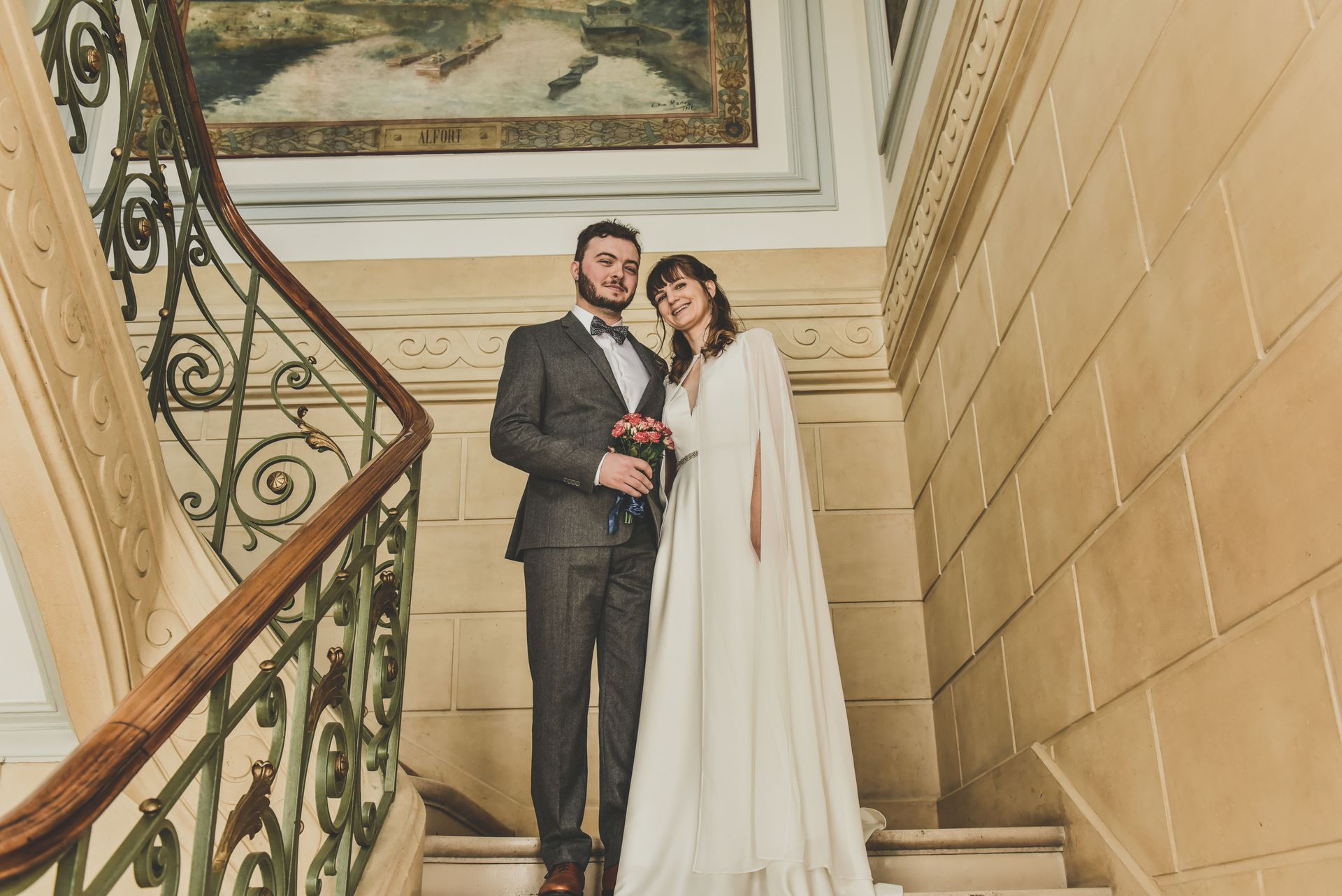 Photo d'un couple le jour de leur mariage, en haut des escaliers