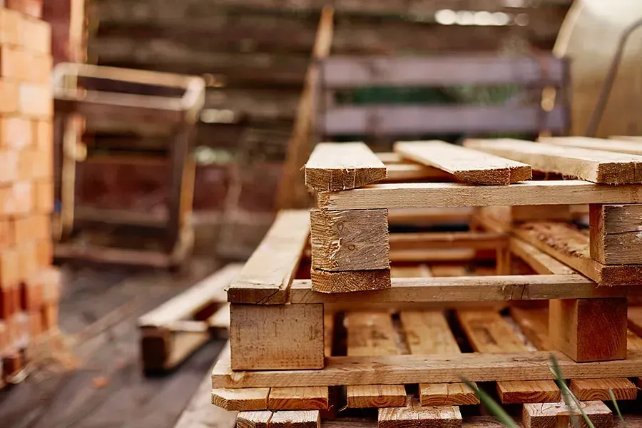 Una pila de paletas de madera apiladas una encima de otra sobre un piso de madera.