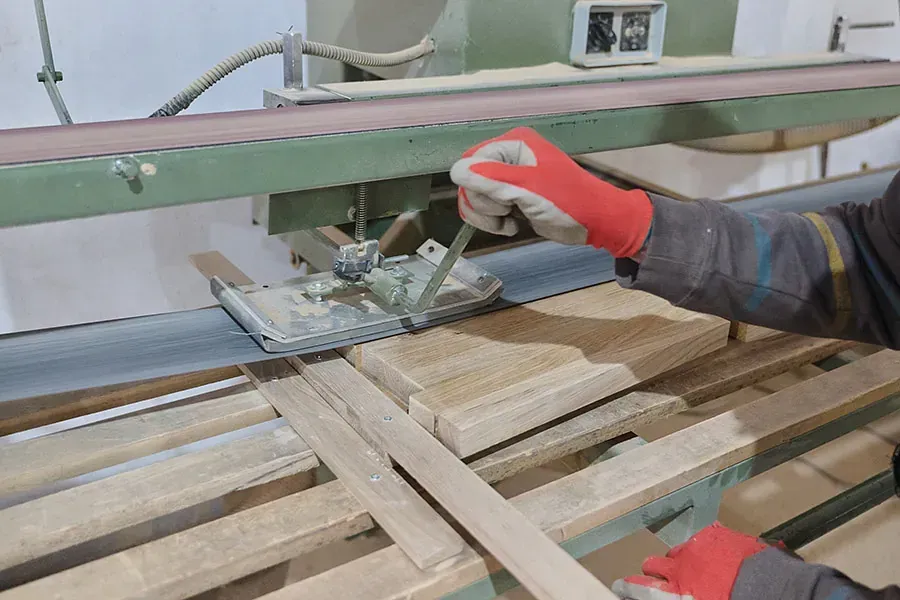 Una persona está cortando un trozo de madera con una máquina.