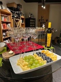 Eine Flasche Wein steht auf einem Tisch neben einem Teller mit Käse und Weintrauben.