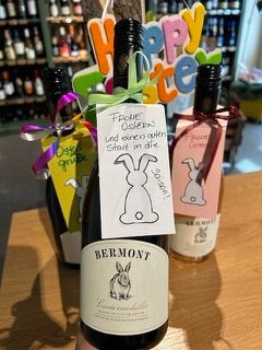 Eine Person hält eine Flasche Wein mit einem Etikett darauf.