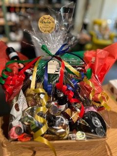 Auf einem Holztisch steht ein Korb voller Essen und Bänder.