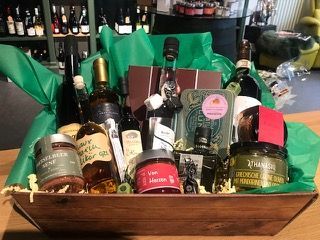 Ein Holzkorb gefüllt mit Weinflaschen und anderen Gegenständen.