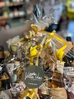 Ein Korb voller Weinflaschen und anderer in Plastik eingewickelter Artikel.