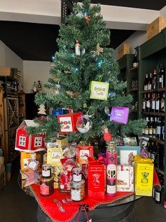 In einem Geschäft steht ein Weihnachtsbaum auf einem Fass.