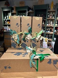 Drei Schachteln mit grünen Bändern stehen auf einem Tisch in einem Geschäft.