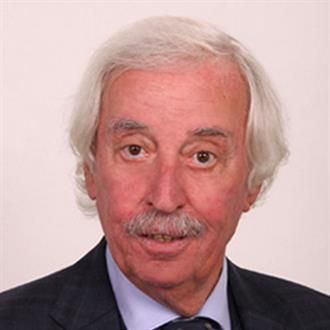 Ein Mann mit grauem Haar und Schnurrbart trägt Anzug und Krawatte.