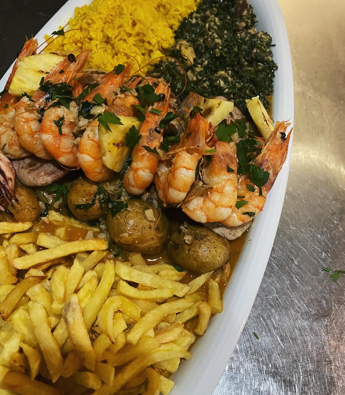 Um prato de comida com camarão, batata frita e arroz