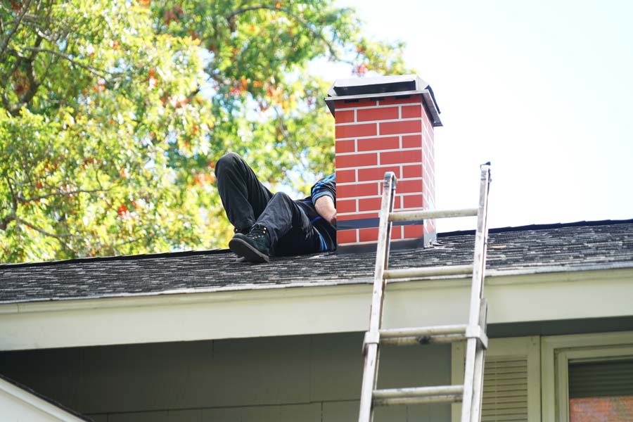 Un homme en train de réparer une cheminée