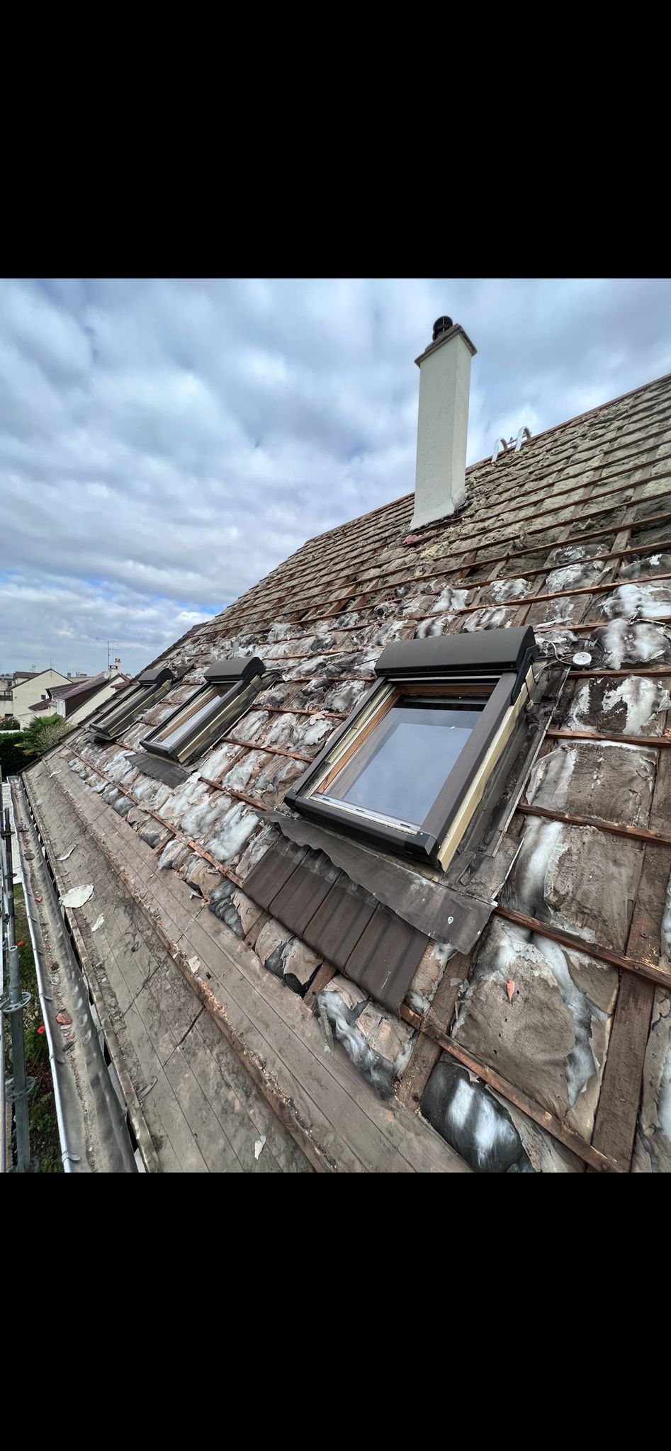 Installation des trois fenêtres de toit d'une toiture en cours de rénovation