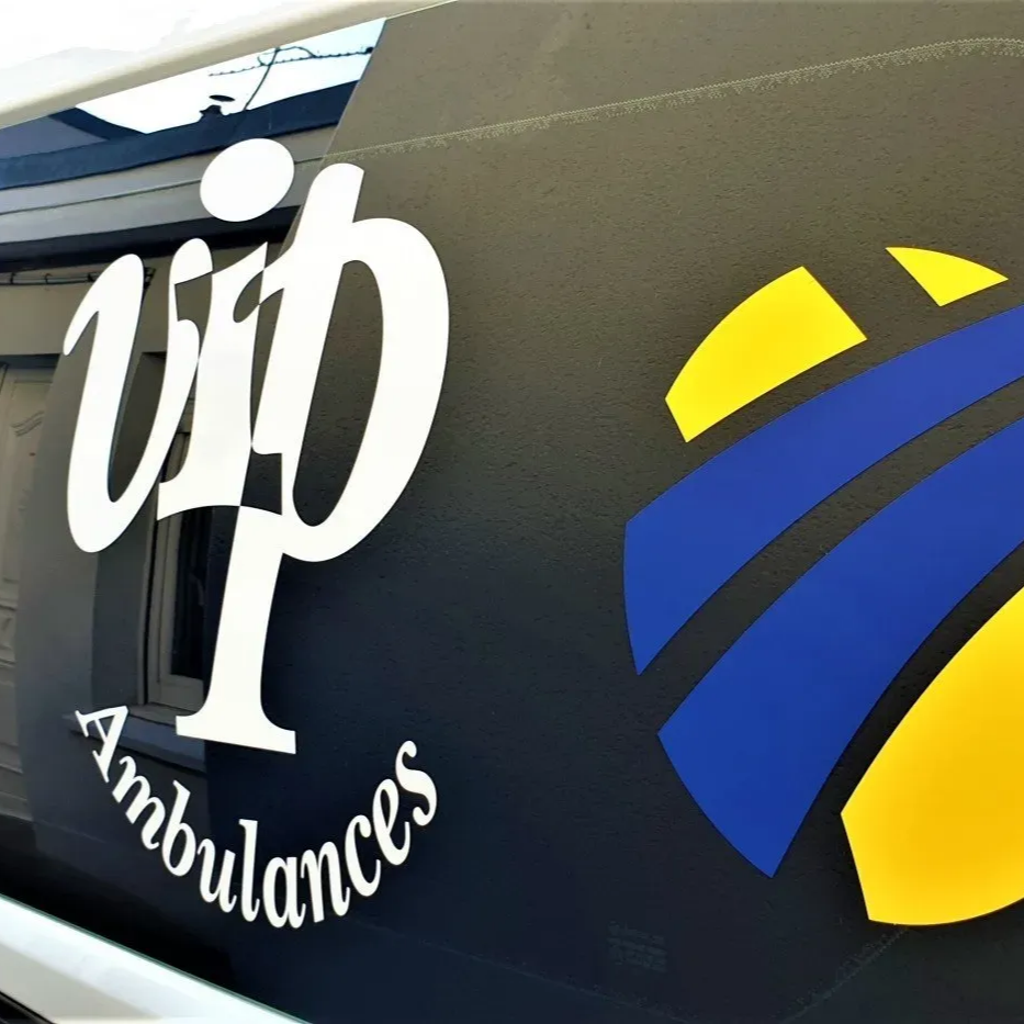 Véhicule noir arborant le logo de VIP Ambulances en blanc et un emblème bleu et jaune.