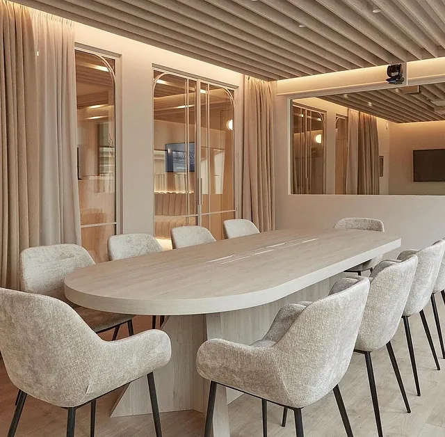 Una sala de conferencias con una mesa larga y sillas
