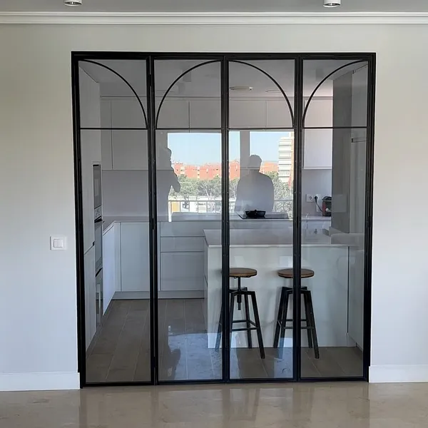 Una cocina con una puerta corrediza de vidrio entre la cocina y la sala de estar.