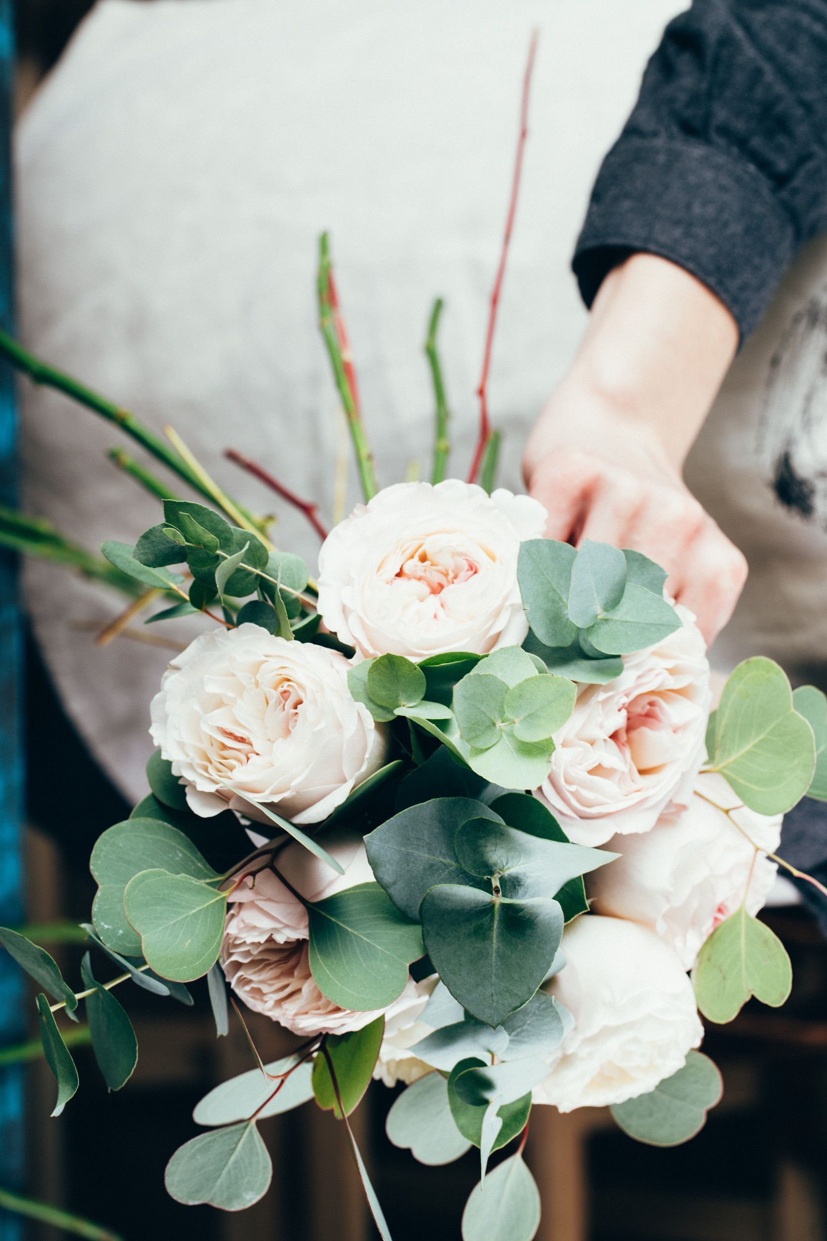Una persona sostiene un ramo de flores en sus manos.
