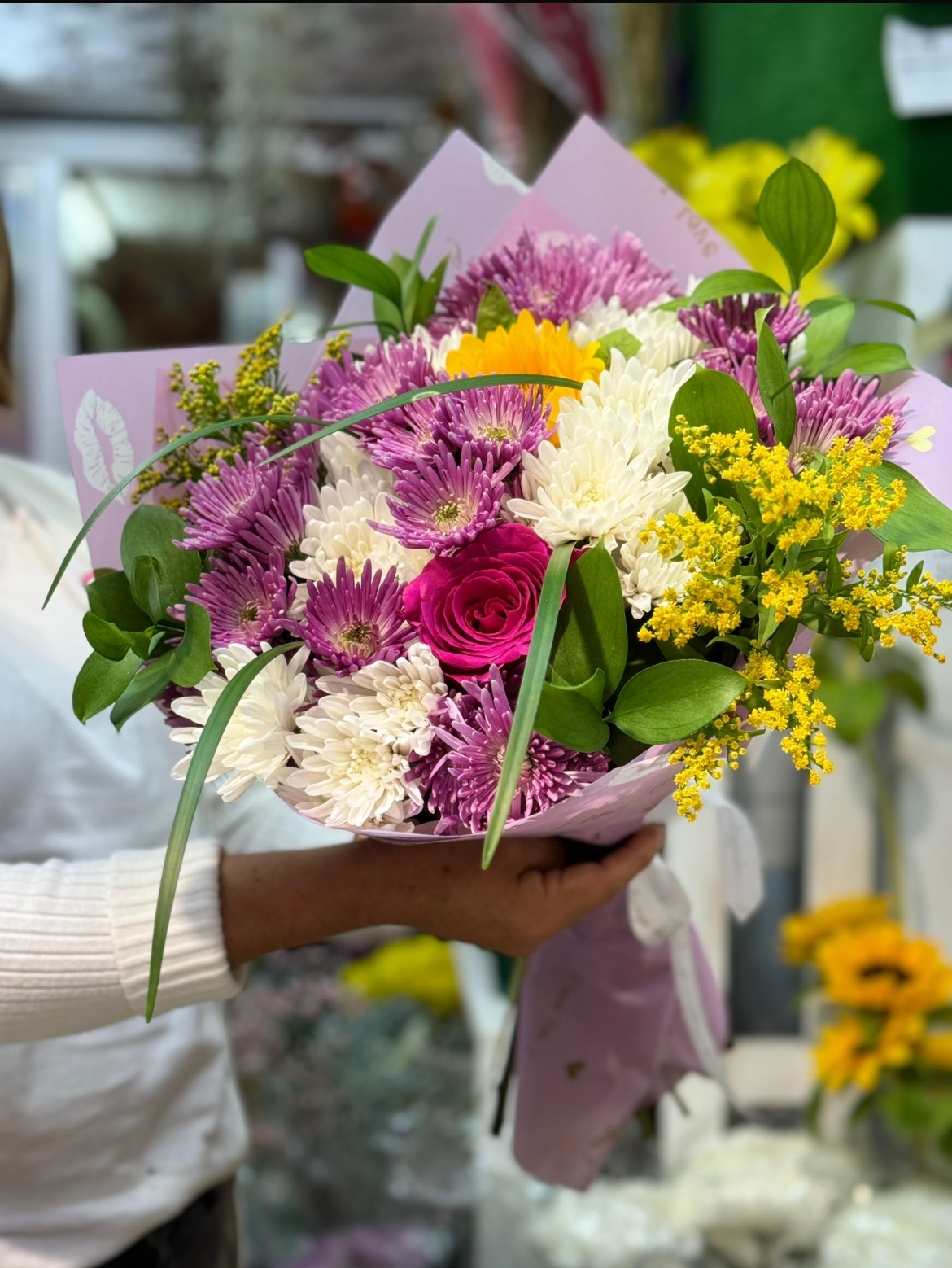 Una persona está cortando flores con tijeras sobre una mesa.