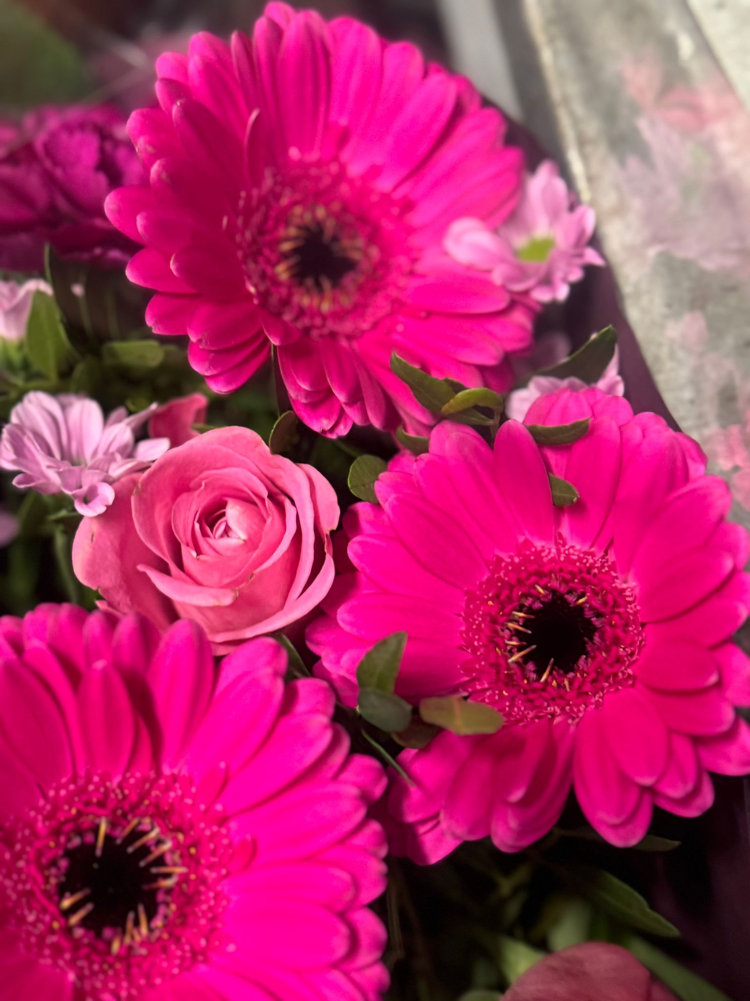 Una mujer está envolviendo un ramo de flores en papel marrón.