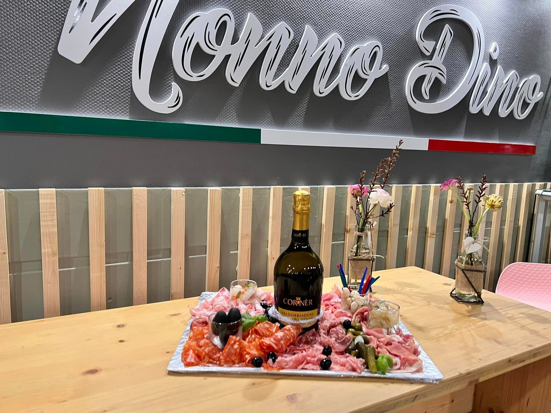 Un petit plateau de charcuterie avec une bouteille de vin