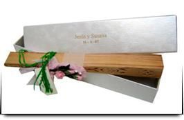 Un abanico de madera está sentado en una caja blanca.