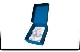 Una caja azul con un cojín blanco dentro sobre un fondo blanco.