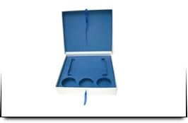 Una caja blanca con un cojín azul dentro.