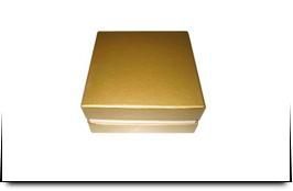 Una caja dorada está sobre una mesa blanca.