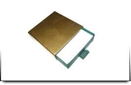 Una caja dorada con un trozo de papel blanco dentro.