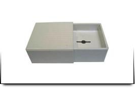 Una caja blanca con una tapa deslizante sobre un fondo blanco.