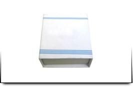 Una caja blanca con una raya azul en el costado está sobre una superficie blanca.