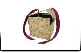 Una caja con una cinta roja alrededor sobre un fondo blanco.