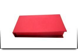 Una caja roja está sobre una superficie blanca.