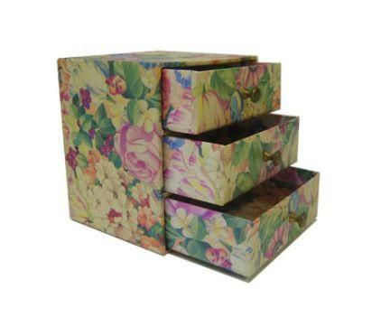 Una caja con tres cajones y un diseño floral.