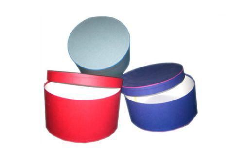 Tres cajas redondas están apiladas una encima de otra sobre un fondo blanco.