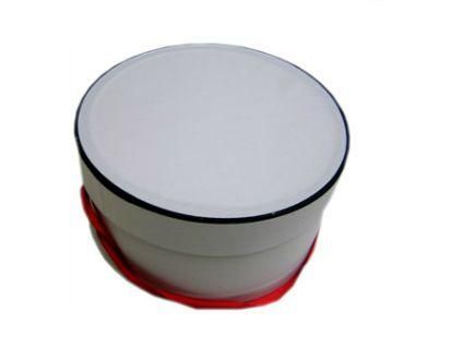 Una caja redonda blanca con un asa roja sobre un fondo blanco.